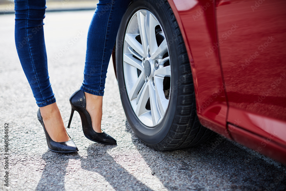 High-heeled black shoes and red car