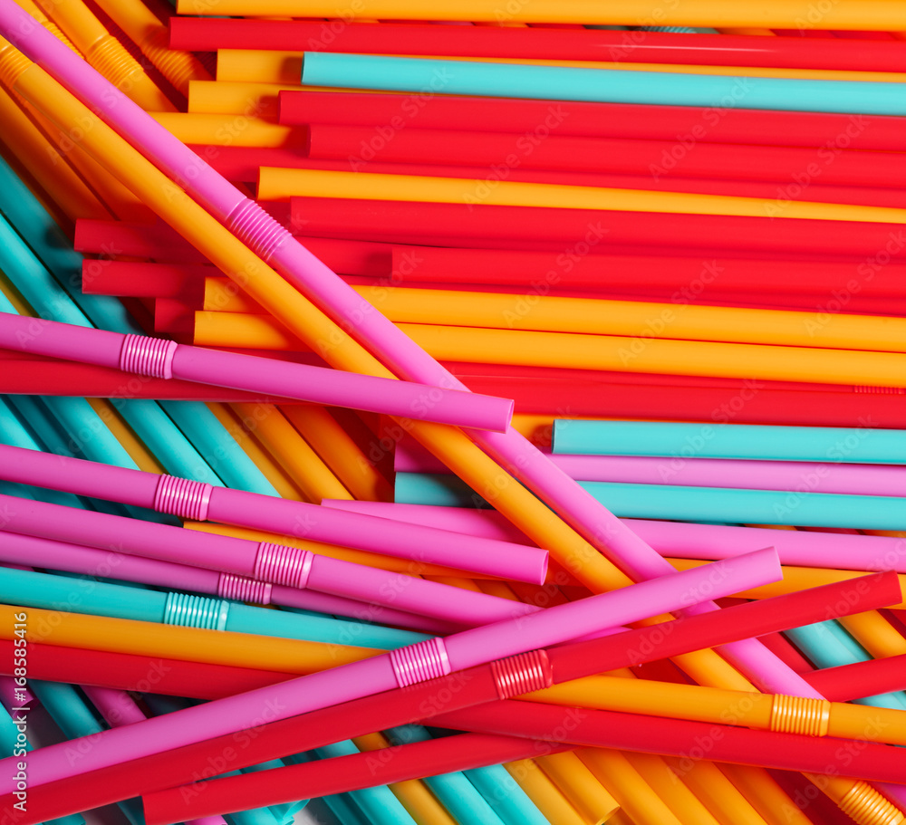 Creative background of striped drink straws in different colors Creative background of striped drink straws in different colors