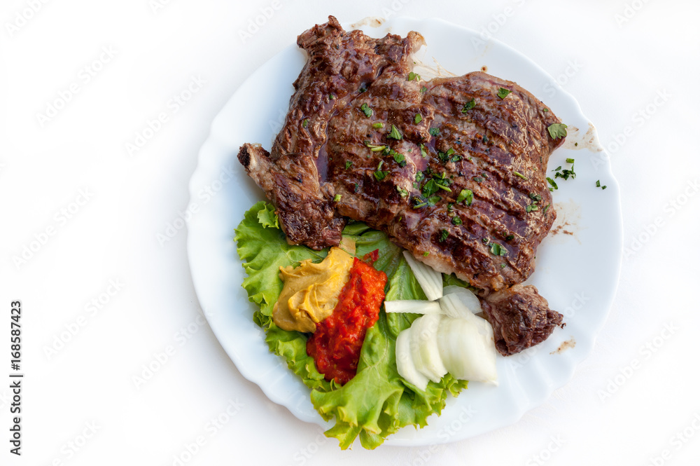 Plate of grilled ribs with traditional Croatian side dish of ajvar
