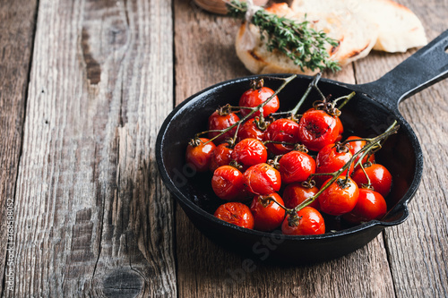 Obraz na plátně Roasted cherry tomatoes  in cast iron skillet