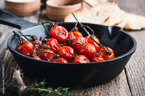 Fotografie Roasted cherry tomatoes  in cast iron skillet