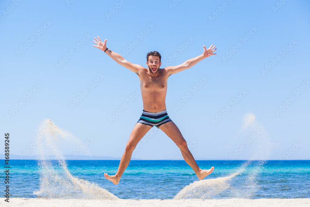 Happy young man jumping at the beach Happy young man jumping at the beach