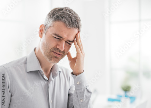 Stressed man with headache photo