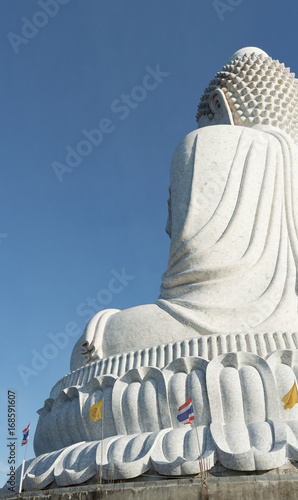 Back view of the white marble statue of Big Buddha on blue sky background photo