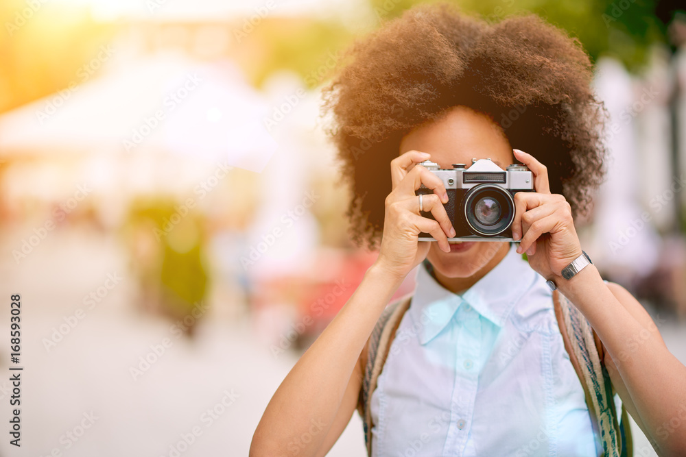 Mixed race tourist taking photo while standing at the street