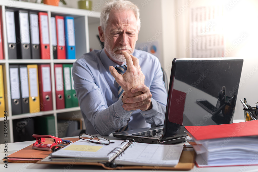 Businessman suffering from wrist pain Businessman suffering from wrist pain