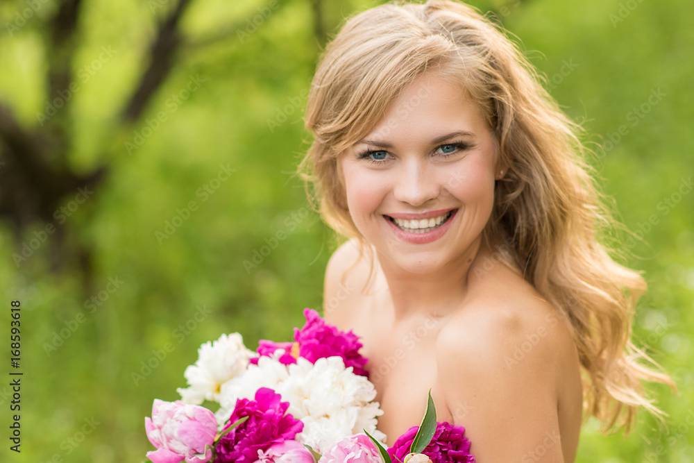 Beautiful smiling woman with a wreath of peonies on the head, holding a bouquet in the nature Beautiful smiling woman with a wreath of peonies on the head, holding a bouquet in the nature