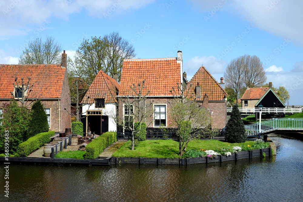Red bricks house in countryside near the lake with mirror reflection in water Red bricks house in countryside near the lake with mirror reflection in water