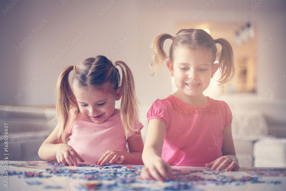 Fototapeta premium Girls playing at home. Girls playing with Bricks at home.