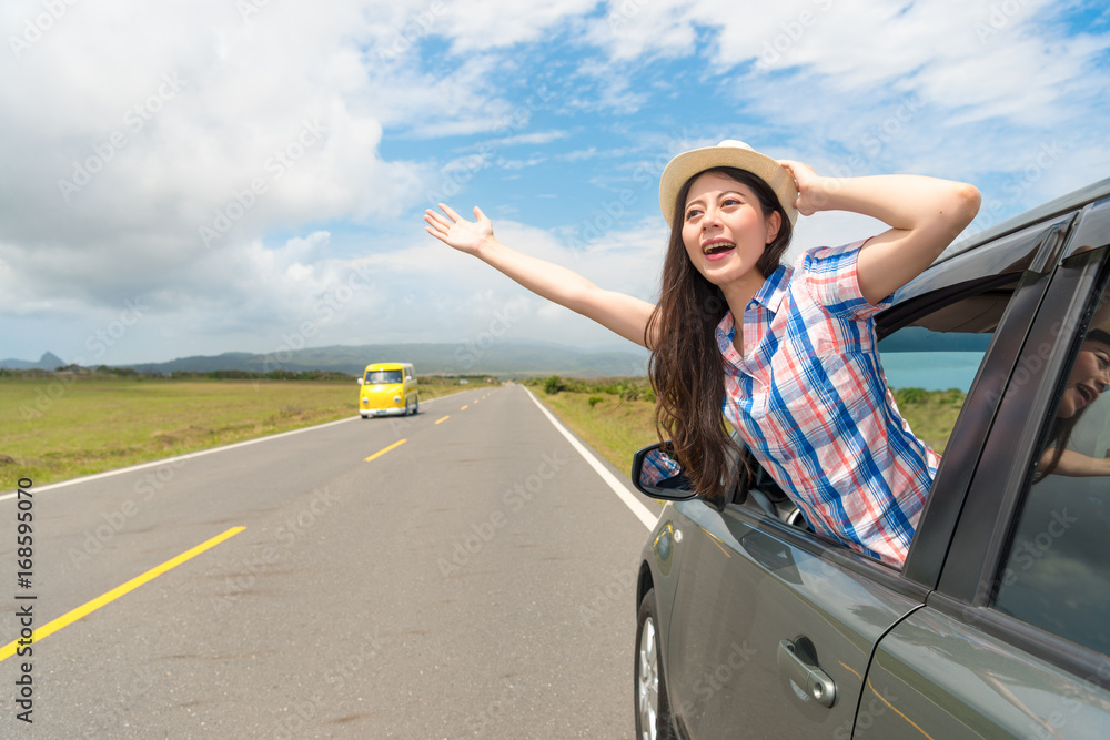 happy female traveler stuck out car window happy female traveler stuck out car window