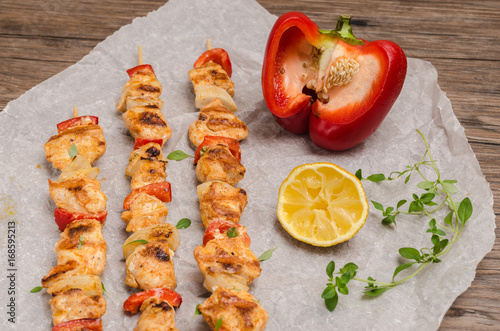 Skewers of grilled chicken satay with red peppers and onions