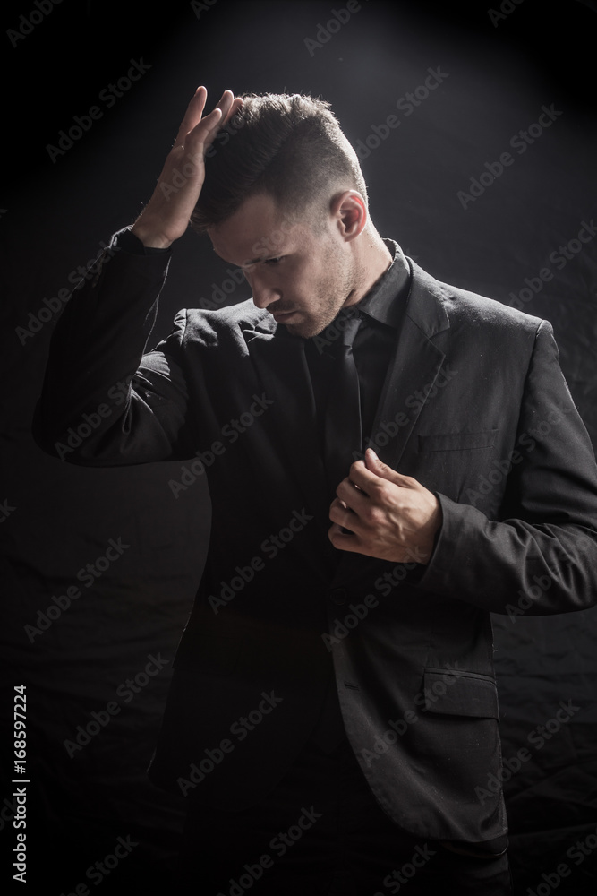 Fototapeta premium man sexually removes clothes on a dark background