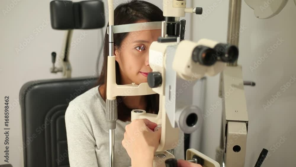 Woman checking vision with tonometer at optical clinic Woman checking vision with tonometer at optical clinic