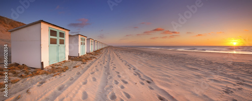 Row of beach huts at sunset, Texel island, The Netherlands photo