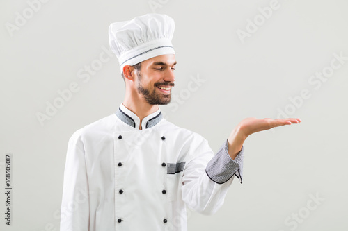 Chef gesturing on gray background.