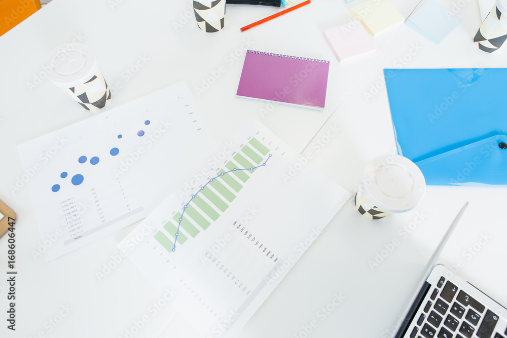 Paper cups on desk with diagrams Paper cups on desk with diagrams