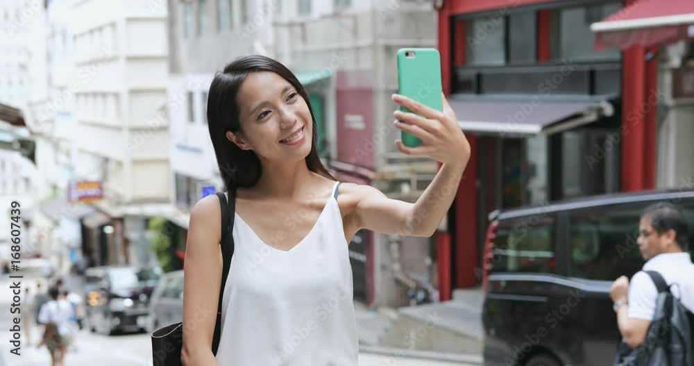 Woman taking selfie by mobile phone in Hong Kong Woman taking selfie by mobile phone in Hong Kong