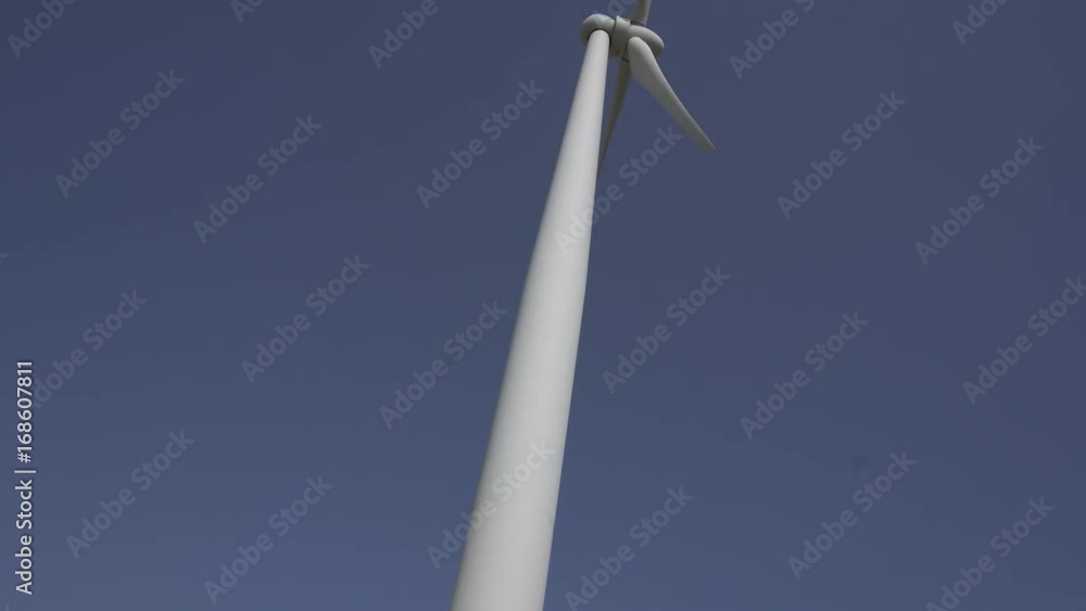 Low angle shot of a wind turbine with rotating blades Low angle shot of a wind turbine with rotating blades