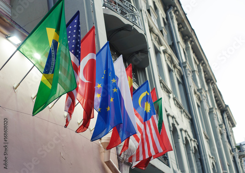 National flags of Brazil, the USA, Turkey, the European Union, Russia, China and Malaysia on the wall of the building