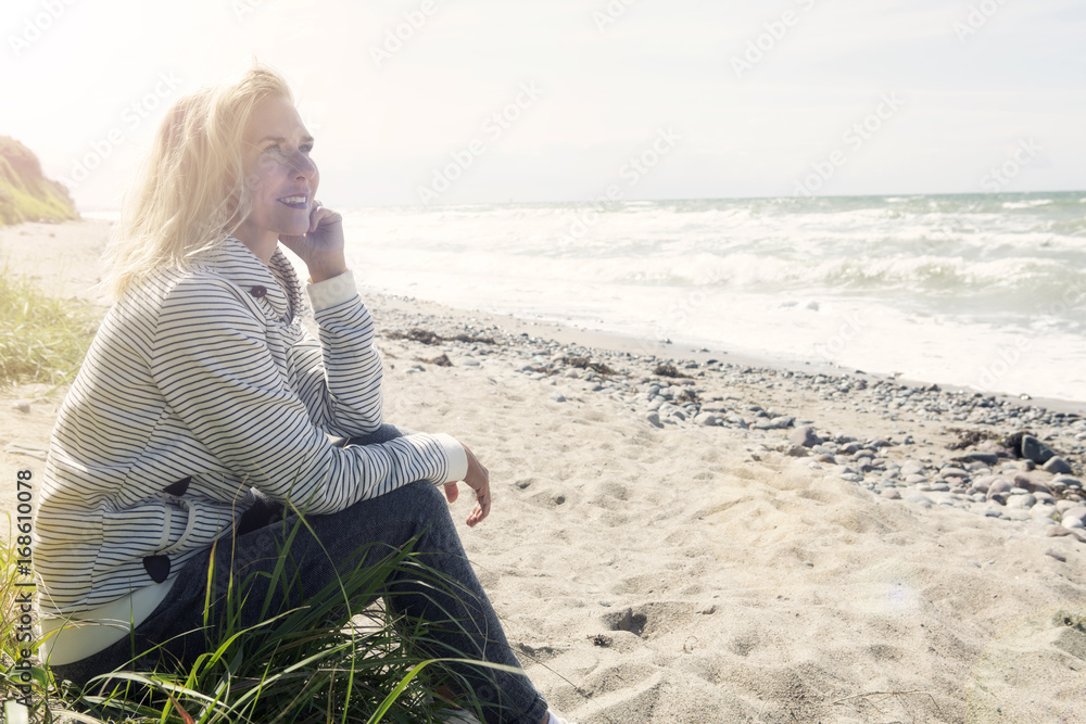 beautiful blond woman sitting on the beach