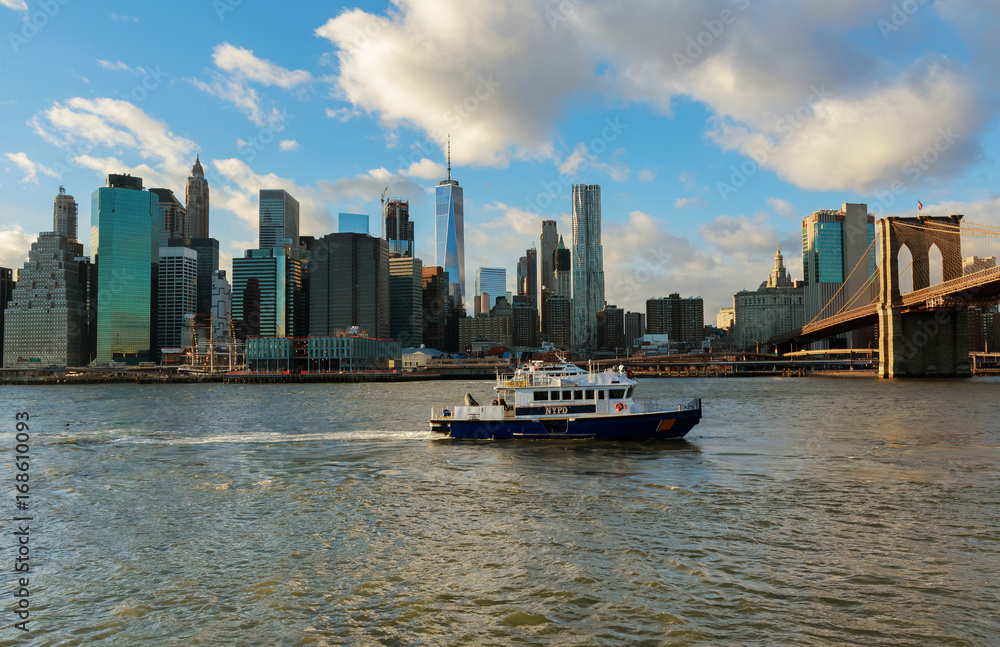 New York City, USA - August 16, 2017: American police boat N.Y.P.D patrolling under the Brooklyn Bridge