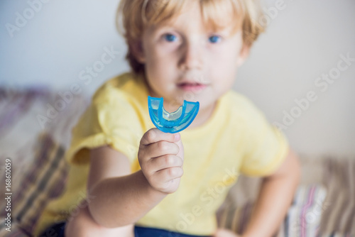 Three-year old boy shows myofunctional trainer to illuminate mouth breathing habit. Helps equalize the growing teeth and correct bite. Corrects the position of the tongue photo