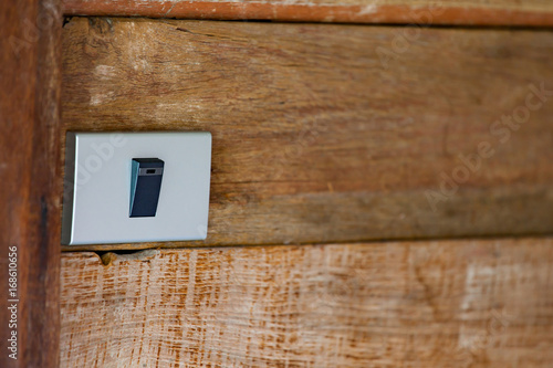 Traditional toggle white house electric light switch in Off position on wood wall