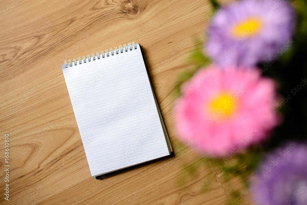 Notepad for entries with flowers on the table.