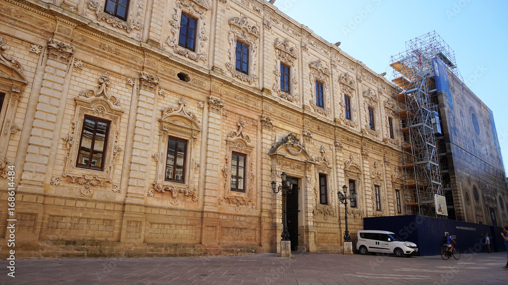 LECCE, ITALY - AUGUST 2, 2017: Celestini Palace with Basilica di Santa Croce in renovation, Lecce, Italy