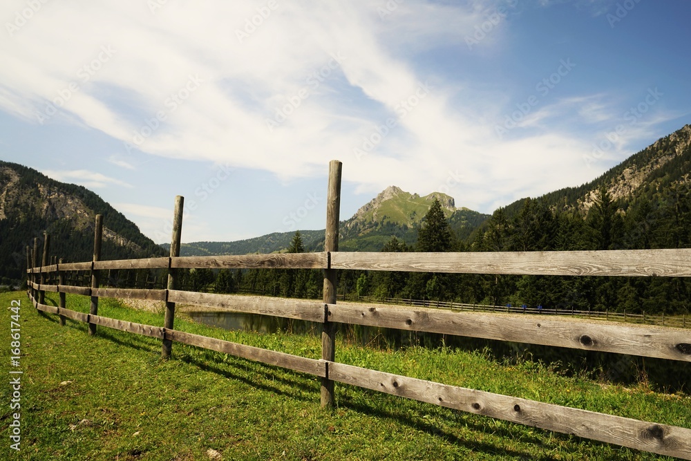 Wooden fence in the Alps under blue sky