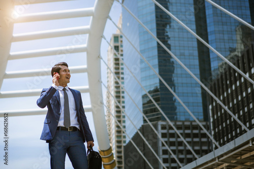 Wallpaper Mural Asian business man use phone talking at outdoor of building Torontodigital.ca