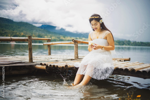 The girl is sitting feet kicked water.
