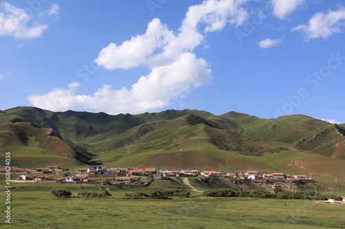 green landscape and mountains surrounding village,Gansu Province,China