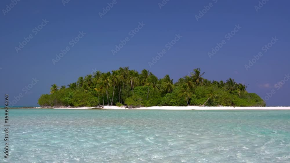 Tropical island at maldivian atoll in Indian Ocean. Wild and uninhabited coast with palm trees. Travel destinations Tropical island at maldivian atoll in Indian Ocean. Wild and uninhabited coast with palm trees. Travel destinations