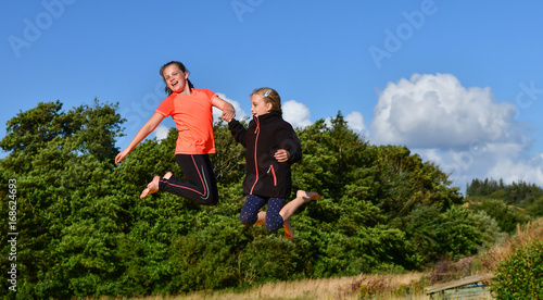 Children having fun jumping on a trampoline on a warm sunny day