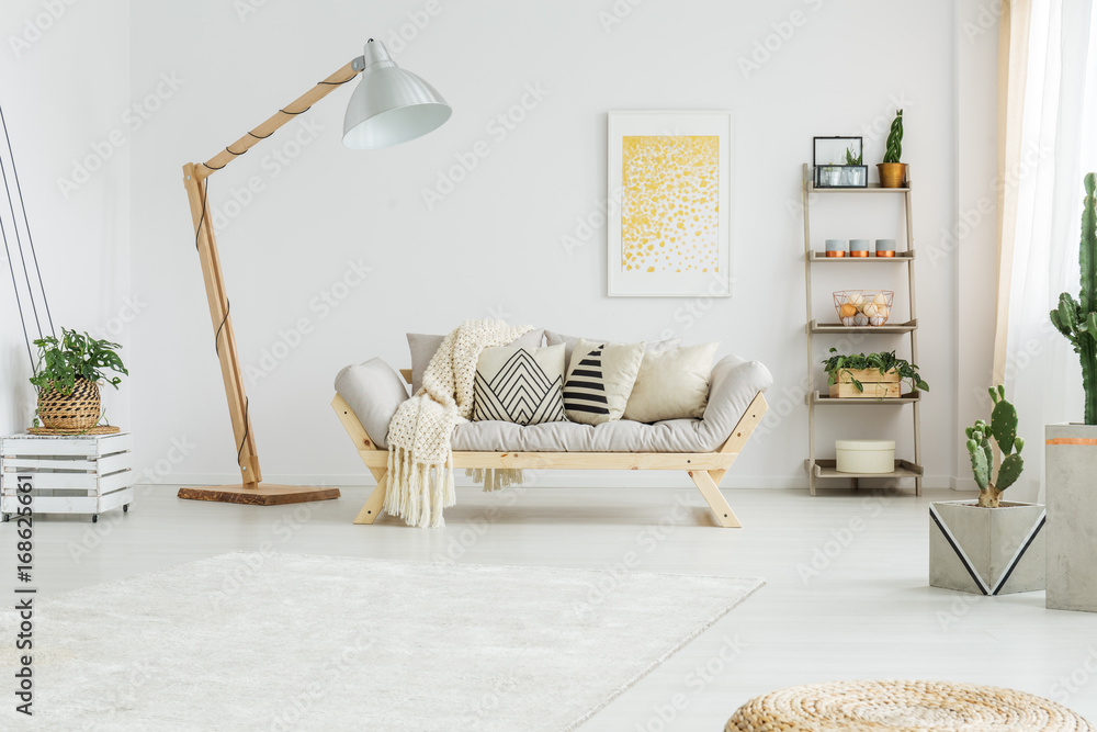 Fototapeta premium Beige coverlet lying on grey sofa