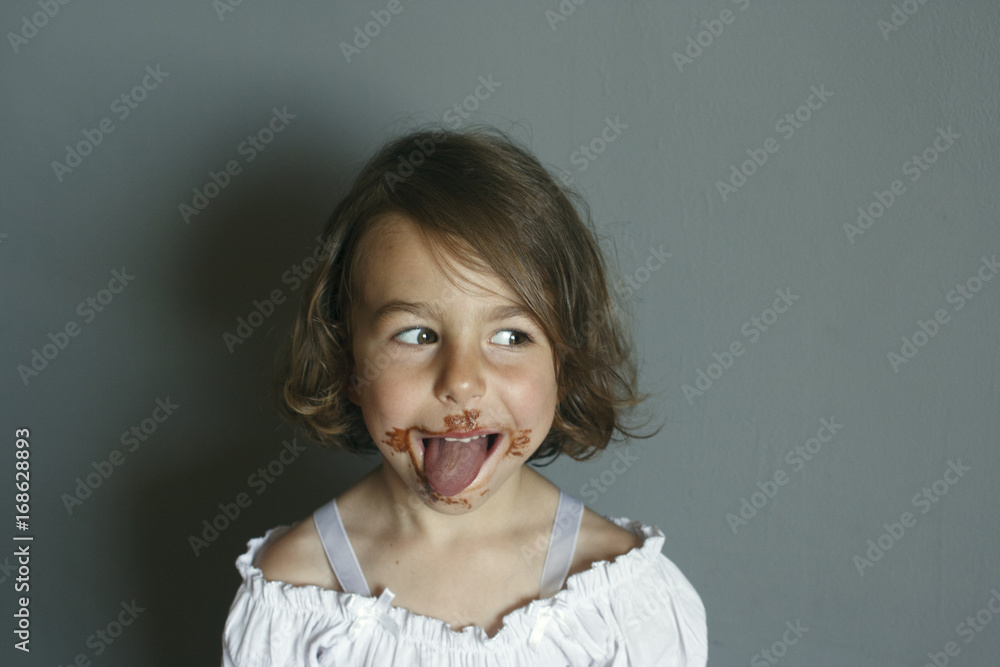 Girl shows the aftertaste from eating a chocolate dessert Girl shows the aftertaste from eating a chocolate dessert