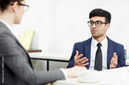Wallpaper Mural Portrait of young bearded entrepreneur conducting negotiations with business partner while sitting at table in spacious boardroom Torontodigital.ca
