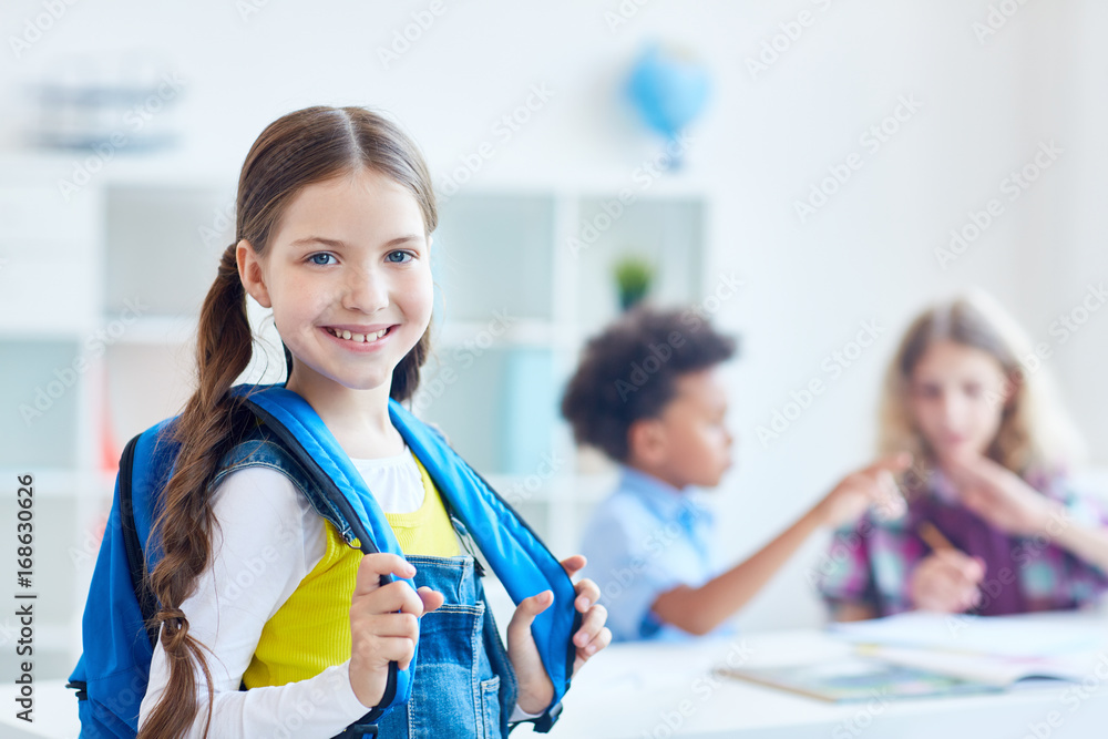 Pretty youngster with rucksack on background of two schoolboys Pretty youngster with rucksack on background of two schoolboys