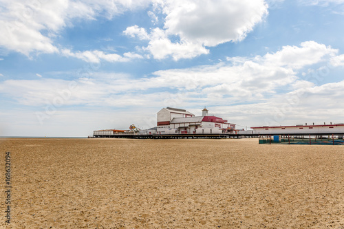 View of a beautiful beach with the pier and some attractions in the background