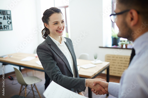Successful man and woman greeting one another after making deal