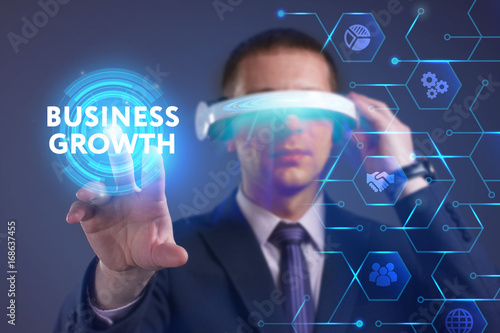Business, Technology, Internet and network concept. Young businessman working on a virtual screen of the future and sees the inscription: Business growth