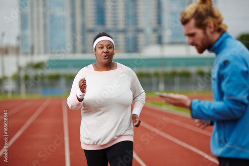Young obese woman taking part in running marathon