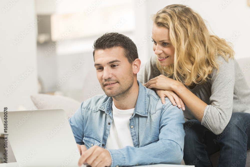 Happy young couple watching internet on their laptop. Happy young couple watching internet on their laptop.