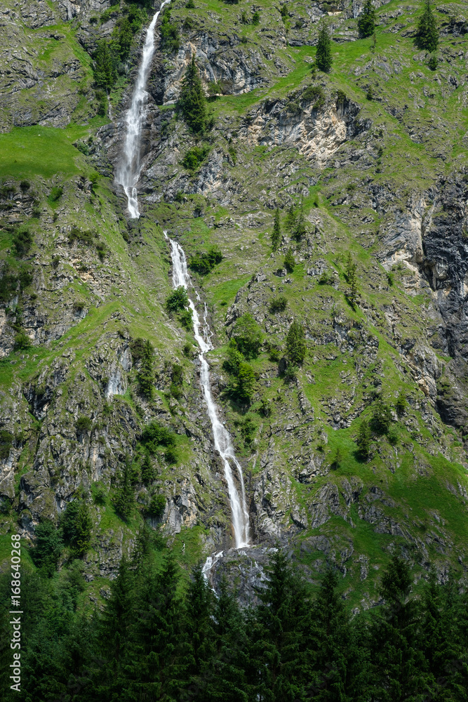 Wasserfall am Berg im Allgäu vor Nadelbäumen Wasserfall am Berg im Allgäu vor Nadelbäumen