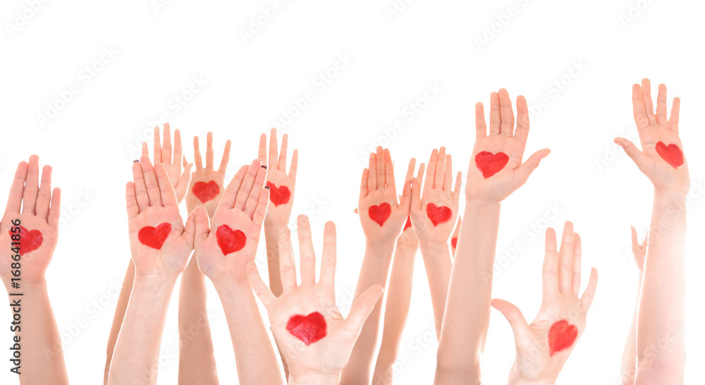 Raised in air hands with drawn hearts on palms against white background. Volunteering concept