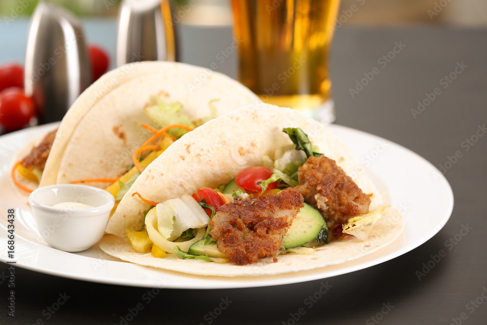 Delicious fish tacos served on white plate on table, close up Delicious fish tacos served on white plate on table, close up