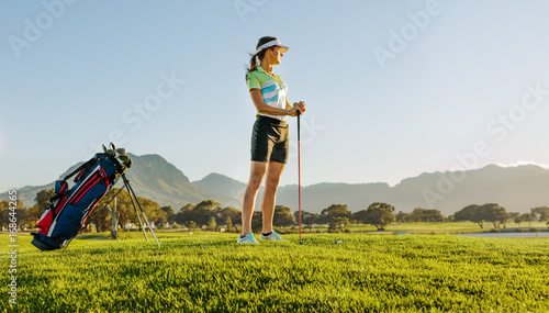 Female golfer on golf course waiting to tee off