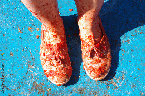  Ludzkie stopy w butach, pokryte pomidorową papką. La tomatina Hiszpania. photo