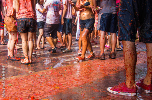 Tłum ludzi bawiących się na La Tomatina. Ujęcie nóg.  photo